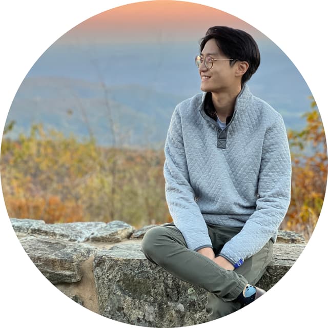 Picture of me sitting on a wall with a sunset behind me.